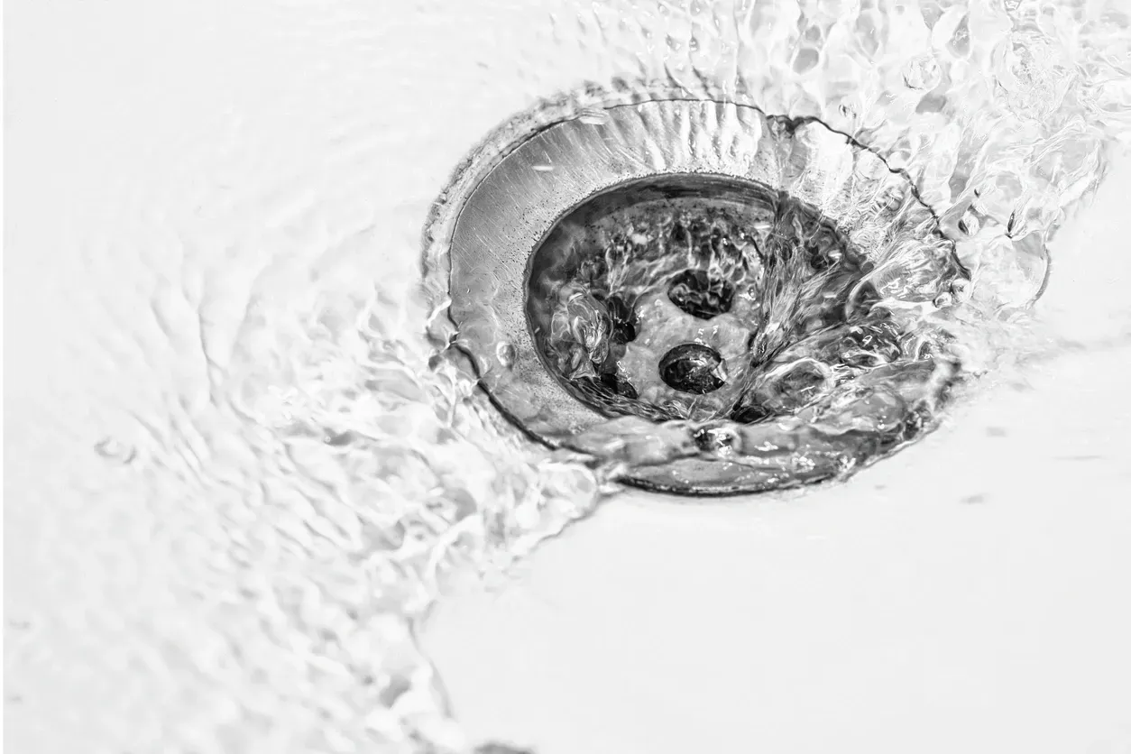 Water flowing through a drain – Drain cleaning and plumbing repair services.
